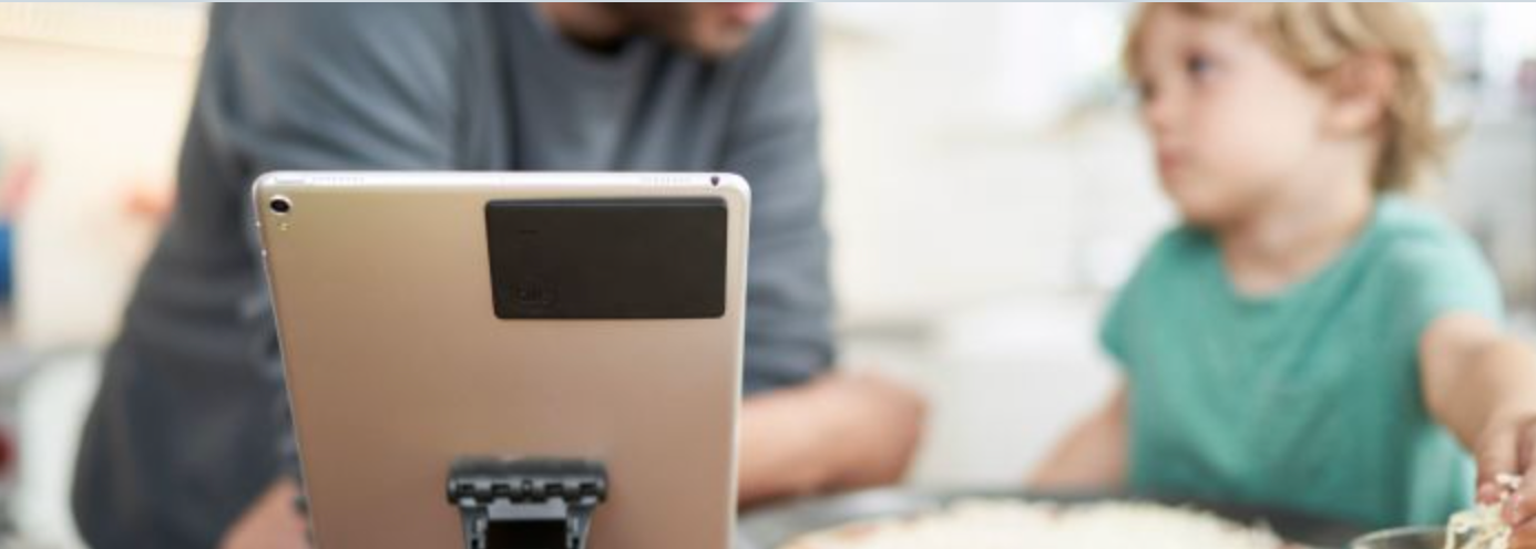 A kindle with a Tile slim attached to it
