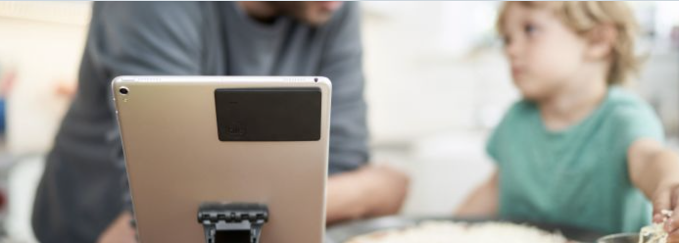 A kindle with a Tile slim attached to it