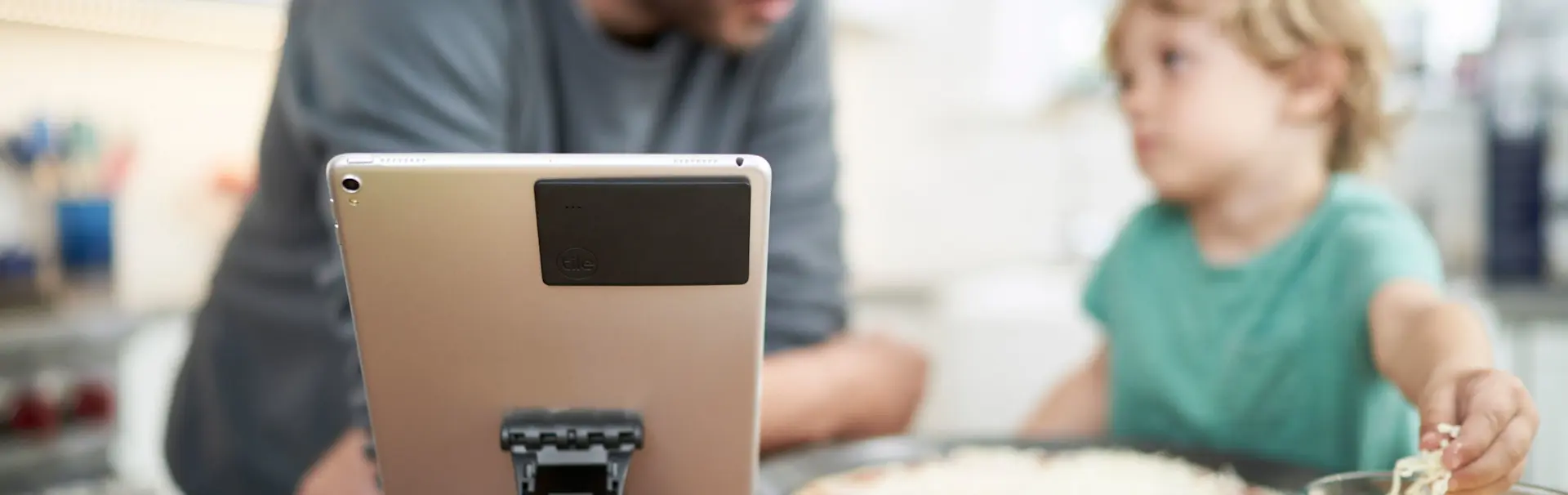 A kindle with a Tile slim attached to it