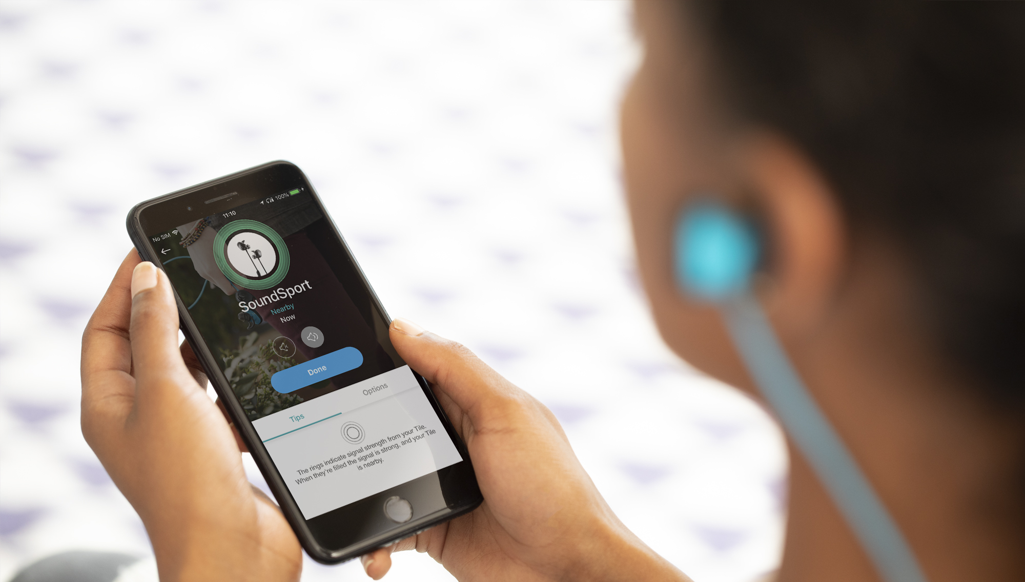 A person finding their earbuds on the Tile app