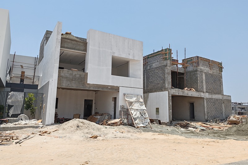 partially_constructed_building_with_exposed_brickwork_and_white_rendered_walls_on_a_construction_site