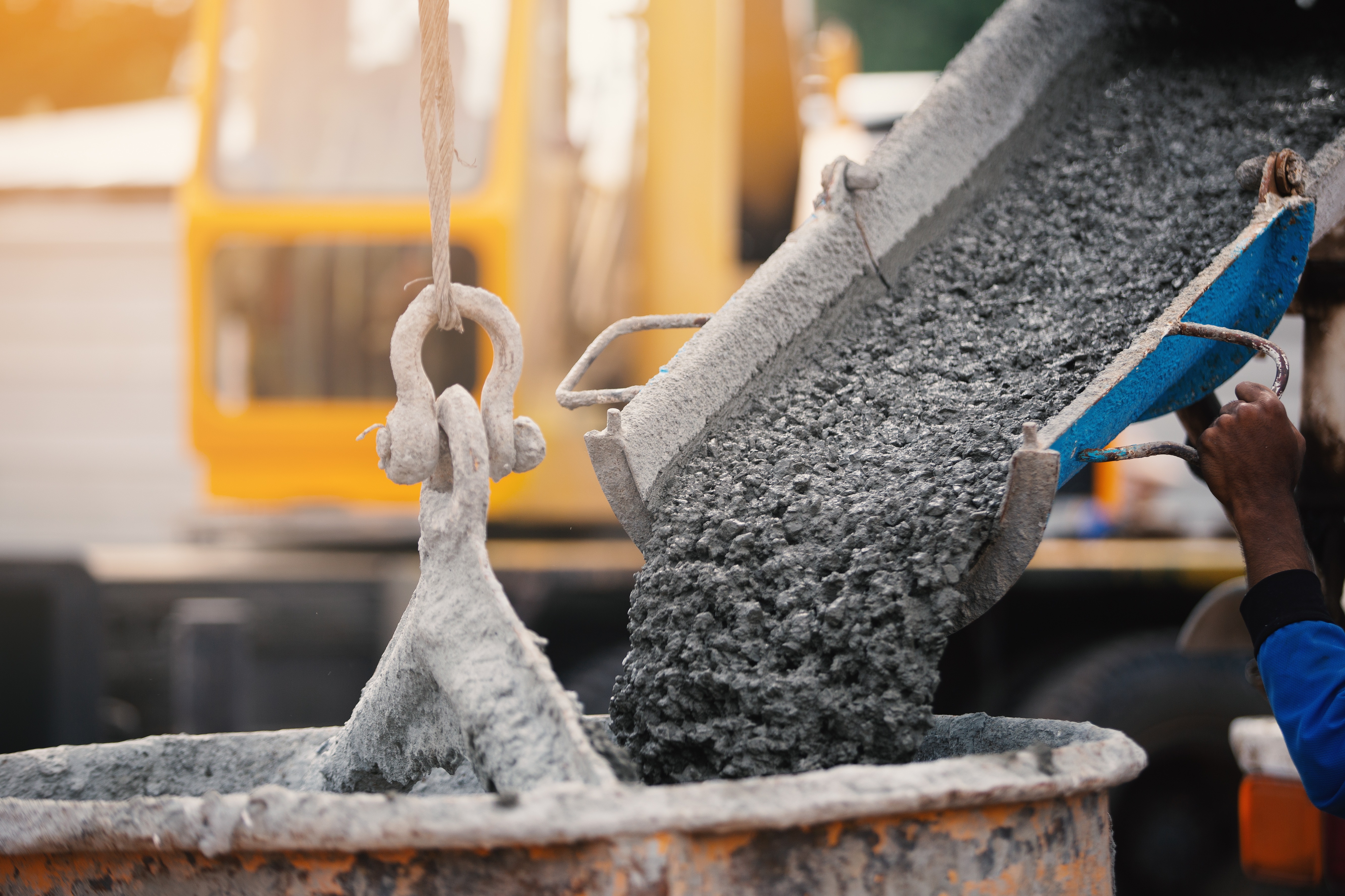 Industrial_construction_machinery_workers_pouring_cement_concrete_using_a_concrete_bucket