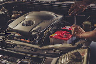 mechanic_fixing_red_car_battery_in_engine_bay