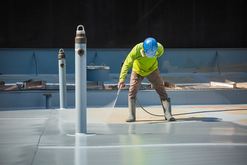 worker_spray_painting_steel_beam_blue_in_industrial_factory_setting