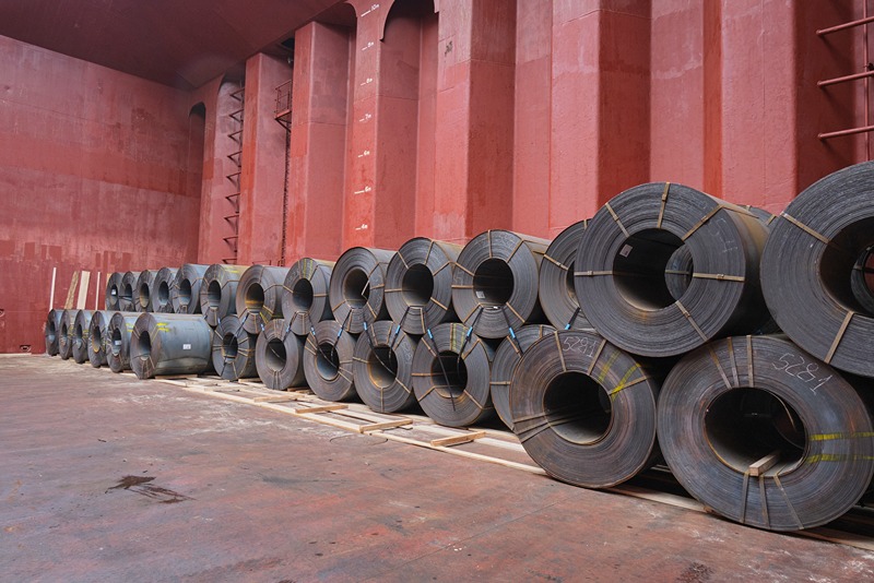 Worker_inspecting_a_large_hot_rolled_steel_coil_used_in_Pre_Engineered_Buildings