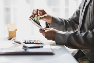 businessman_counting_money_with_a_calculator_on_a_table