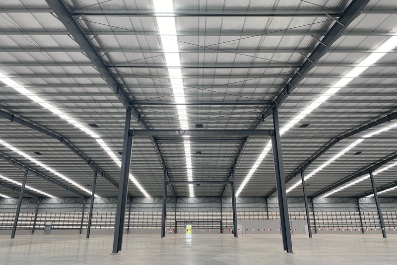 exterior_view_of_a_large_steel-frame_building_with_open_sides_and_support_columns_on_an_industrial_site