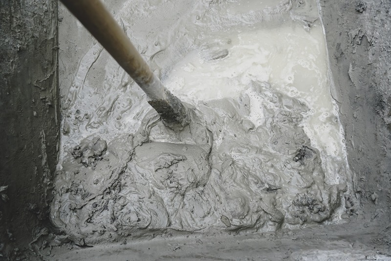 closeup_of_cement_and_water_mixture_during_the_initial_stage_of_hydration_with_a_shovel_for_stirring