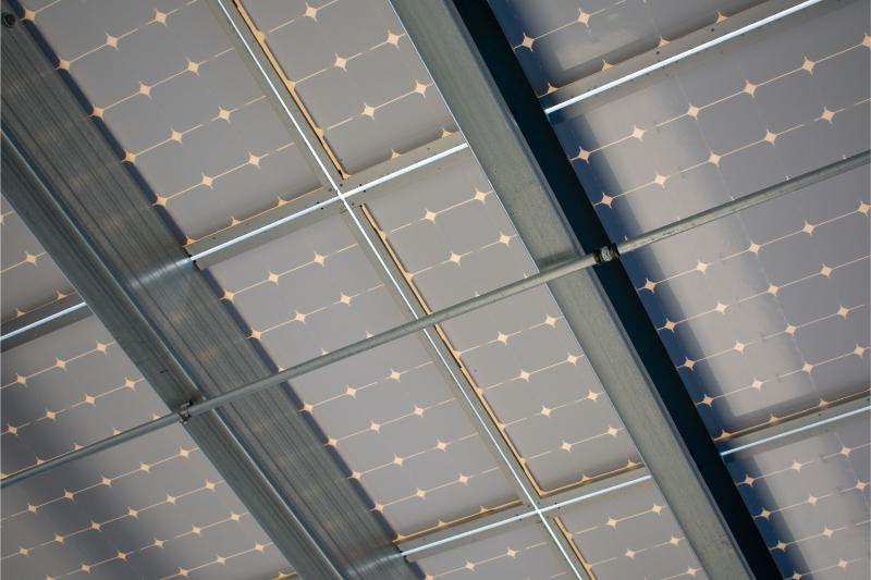 Underside_design_of_a_solar_panels_installed_as_solar_canopy_on_top_of_parking_garage._Solar_panels_convert_the_sun's_rays_into_electricity_and_provide_shade_for_cars.</br>