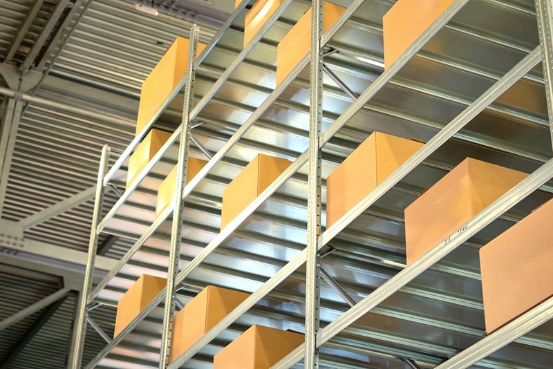 Steel_shelves_with_cardboard_boxes_organised_in_a_modern_industrial_warehouse_for_efficiency_and_space_optimisation.