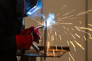 worker_using_precision_laser_tool_on_steel_components_with_sparks