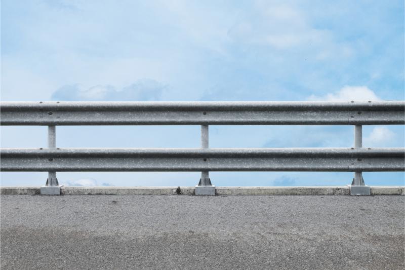 railing_at_roadside_on_a_blue_sky_background