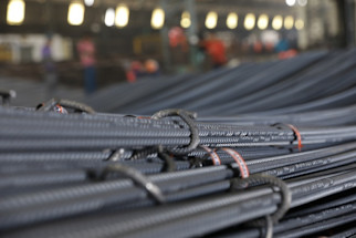 stack_of_steel_tmt_bars_with_blue_marked_ends_and_specification_tag