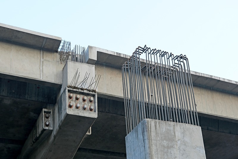 Round_iron_reinforcing_bars_or_rebars_jutting_out_of_unfinished_pillars_and_beams_at_an_ongoing_flyover_project