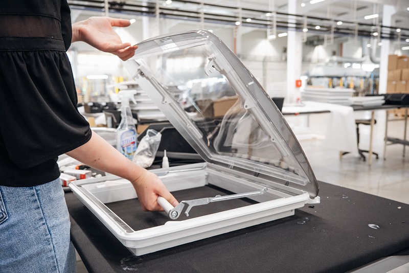 worker_assembling_a_metal_frame_with_hand_lifting_the_top_panel