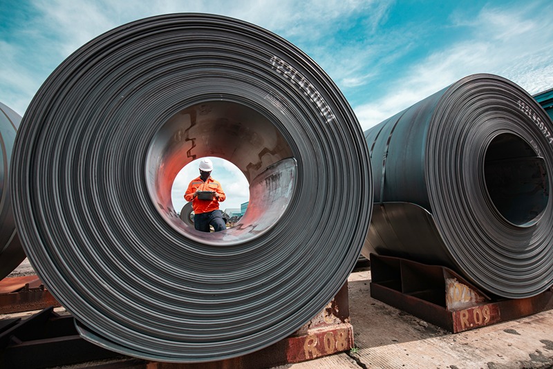 Steel_coils_stored_in_an_industrial_warehouse_ready_for_use_in_PEB_structures