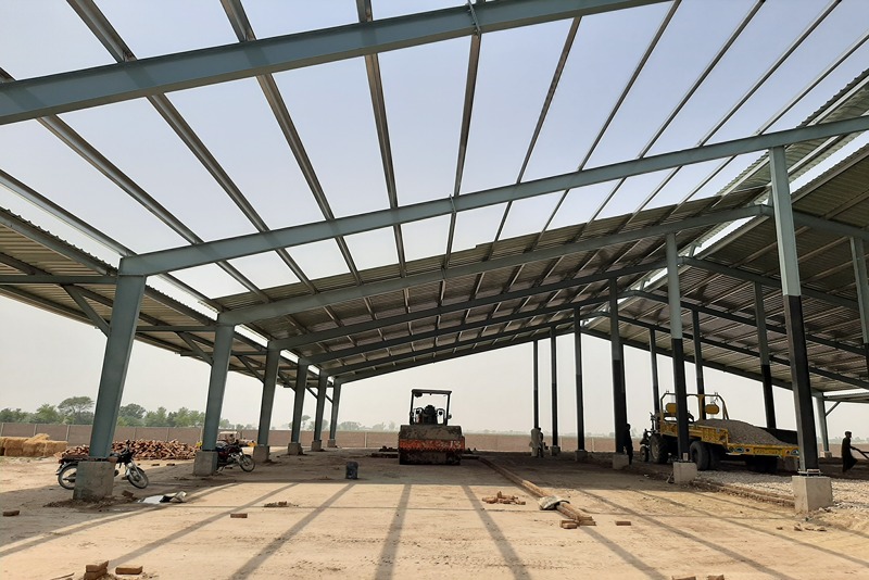 interior_view_of_a_steel_frame_warehouse_under_construction_with_shadows_cast_on_the_ground