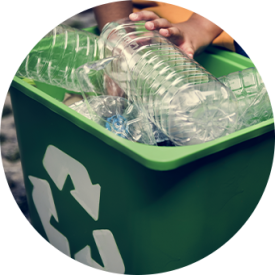 Ronde foto van groene vuilnisbak met plastic flessen en recycle teken. Witte achtergrond.