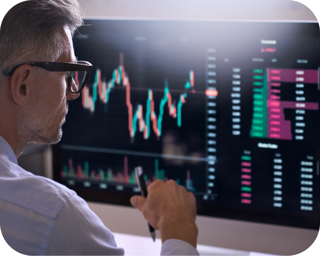 Man looking at a computer screen with charts on it