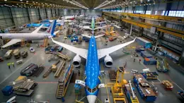 Busy maintenance hangar with multiple aircraft and technicians working.
