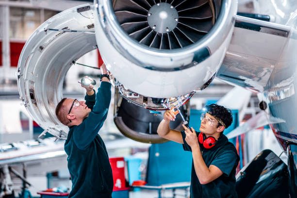 Team of aircraft mechanics working together on aircraft engine.