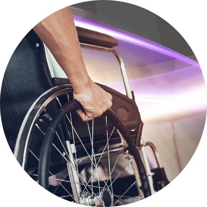 A man is holding a wheel of his wheelchair