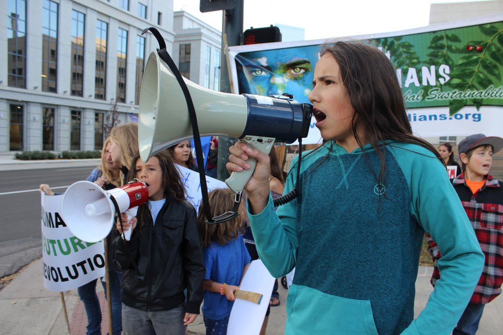 x shouting into megaphone at march