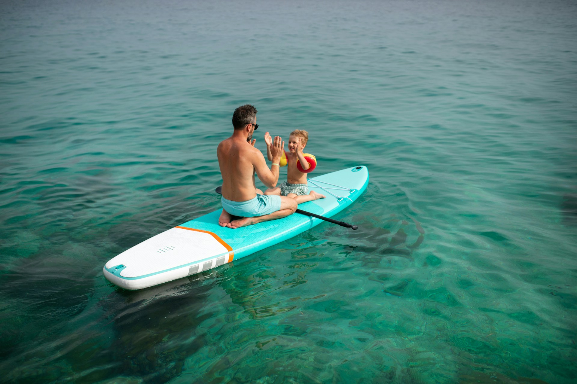 father and son in a paddleboard