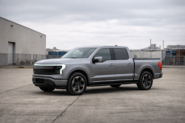 A single modern pickup truck, stationary, photographed in an industrial setting under overcast or soft light.