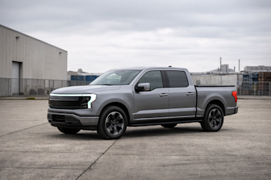 A single modern pickup truck, stationary, photographed in an industrial setting under overcast or soft light.