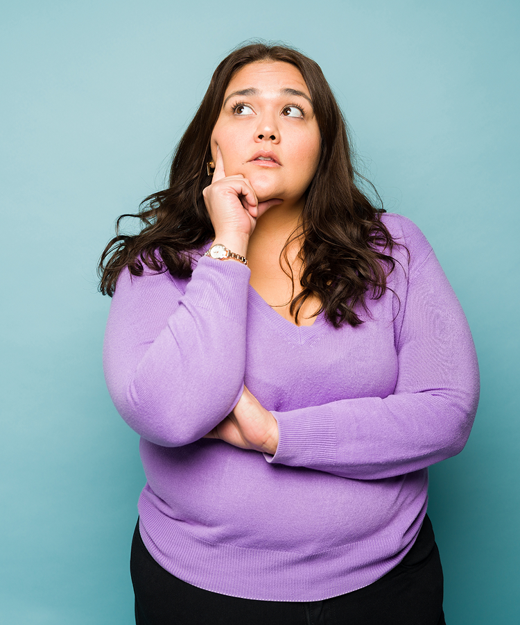 Thoughtful woman in a purple sweater wondering what's inside her pad and how Always uses independent safety testing