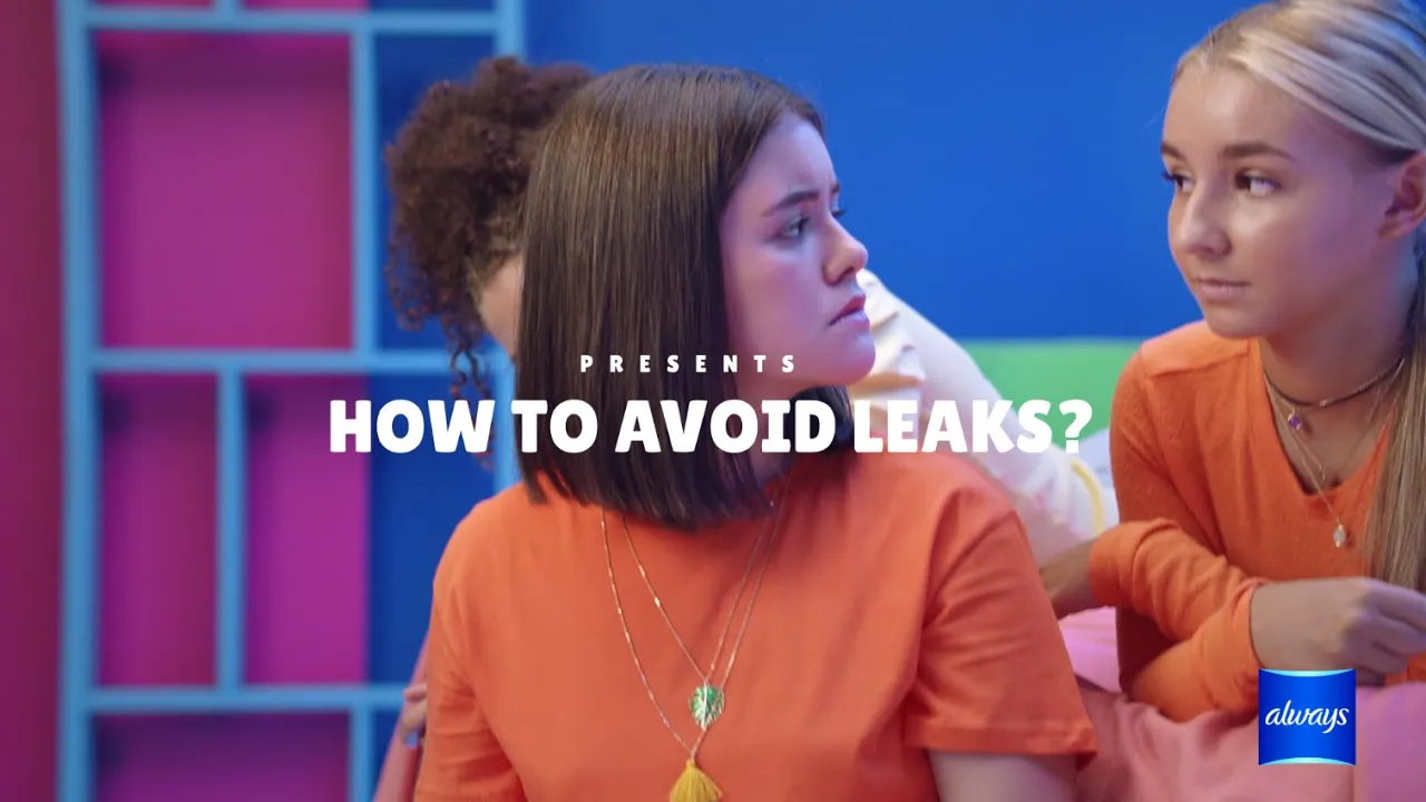 Three young women in orange shirts discuss tips on preventing leaks, set against a colorful background