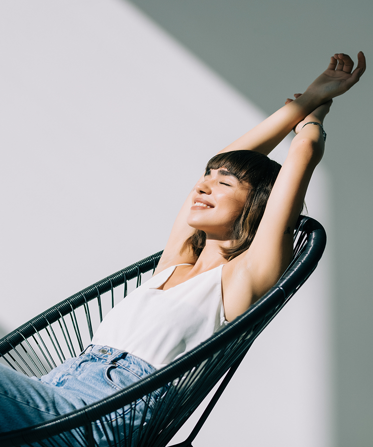 Relaxed woman stretching in a chair, feeling dry and comfortable with thin Always FlexFoam pads