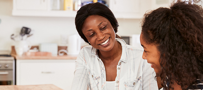 Mother and daughter having pleasant conversation and smiling