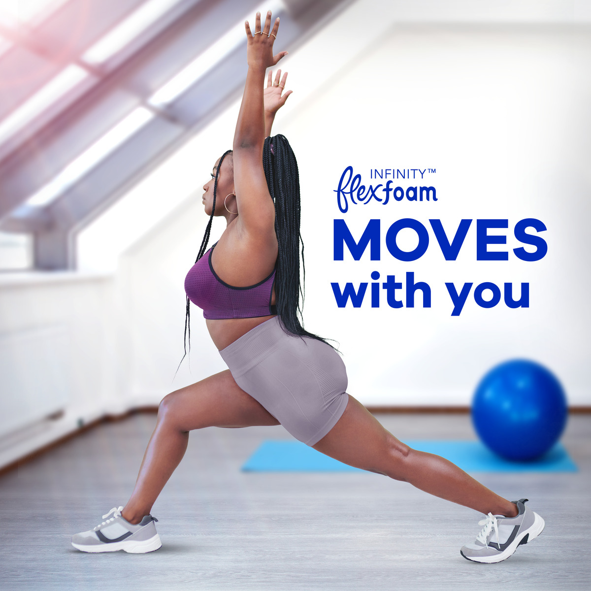 Woman in workout gear performing a lunge stretch indoors, promoting flexfoam's comfort and flexibility. Blue exercise ball in background