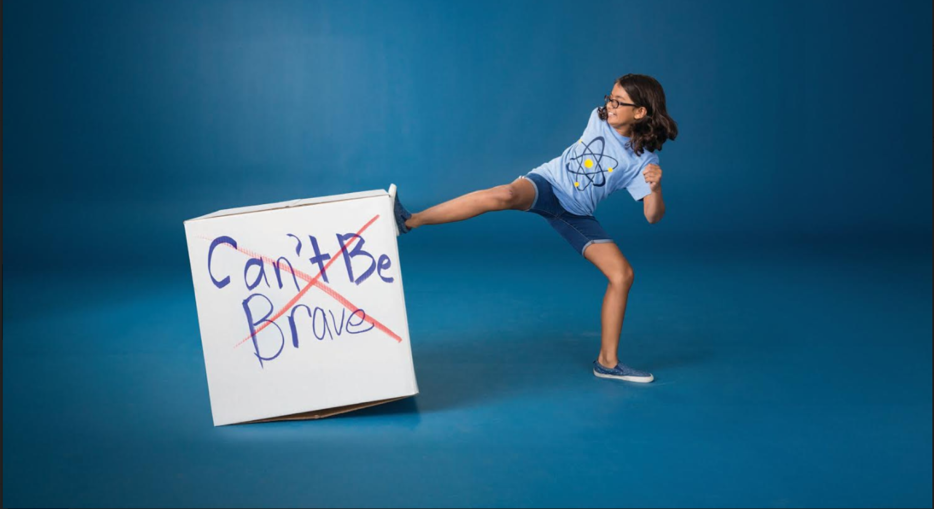 Young brave girl kicks cartoon box