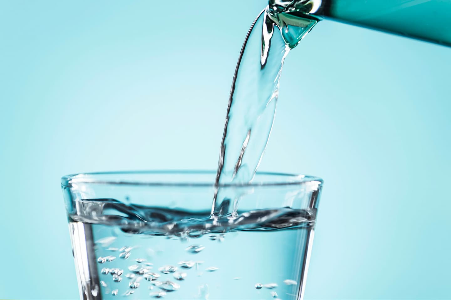 water being poured into a glass cup