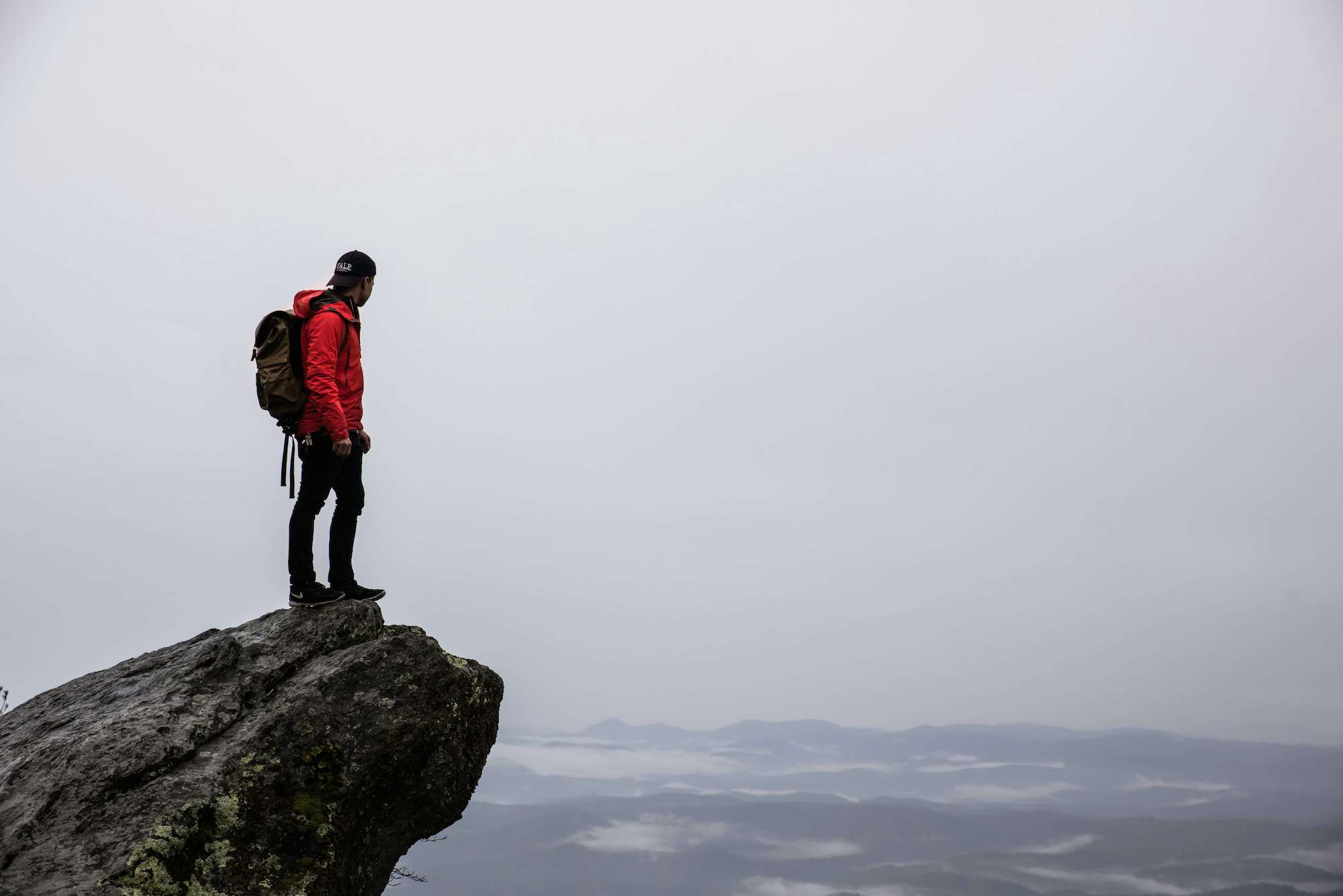 Person standing on gray rock