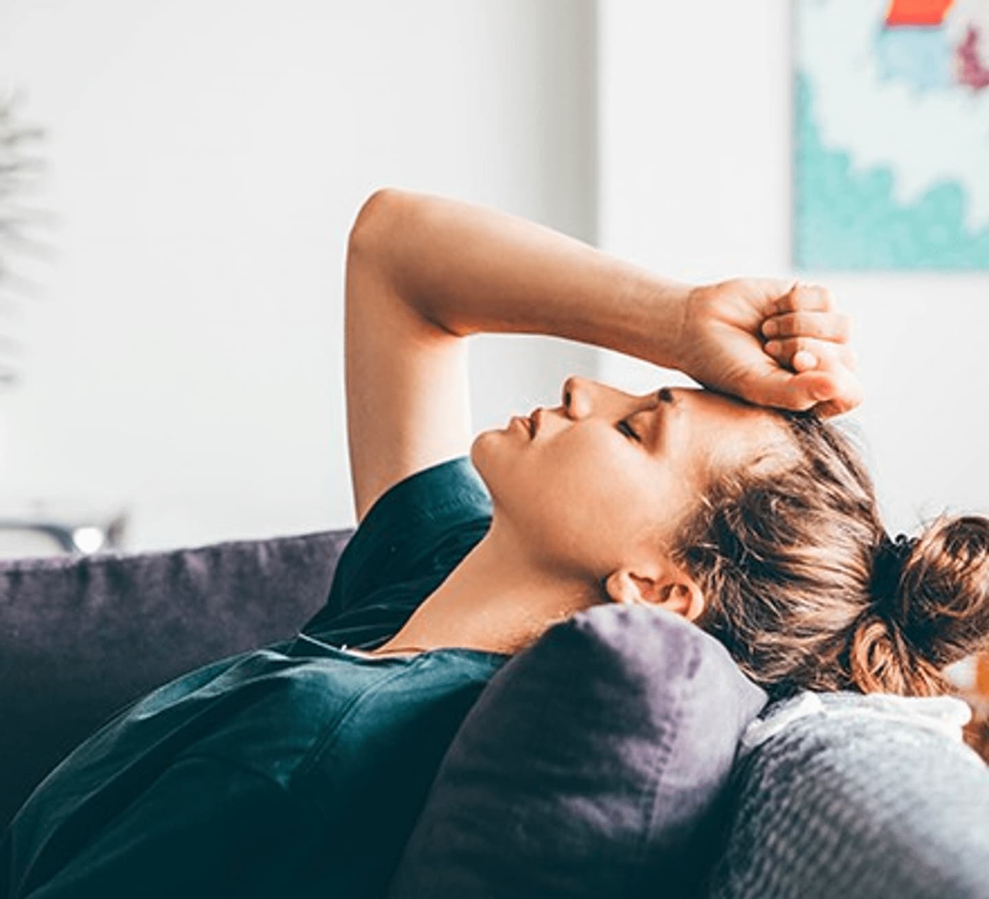 woman on a sofa with headache