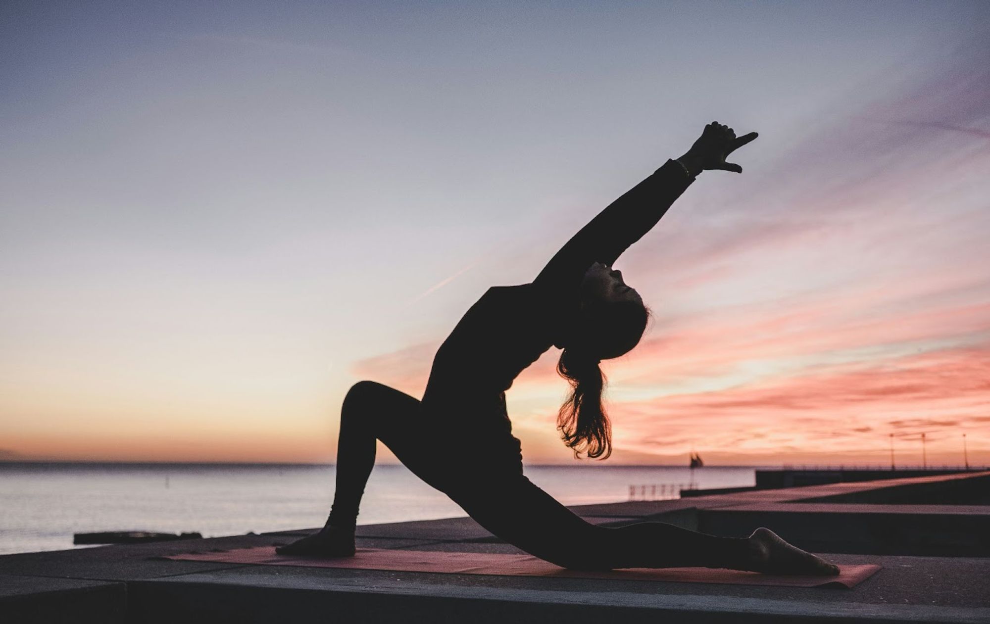 a woman doing yoga at dusk