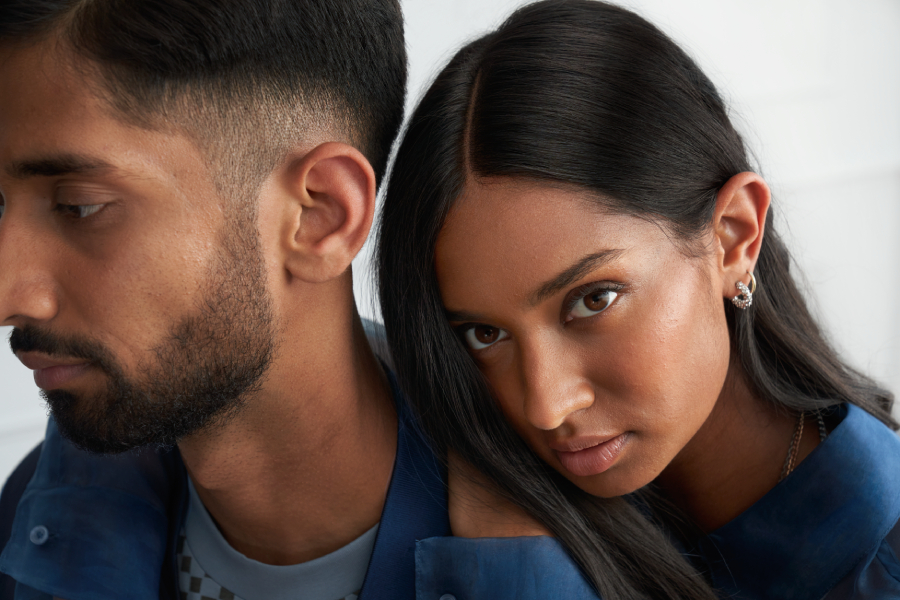 une femme aux longs cheveux noirs est appuyée contre un homme aux cheveux noirs qui regarde devant lui