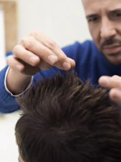 homme qui regarde les cheveux d'un homme brun