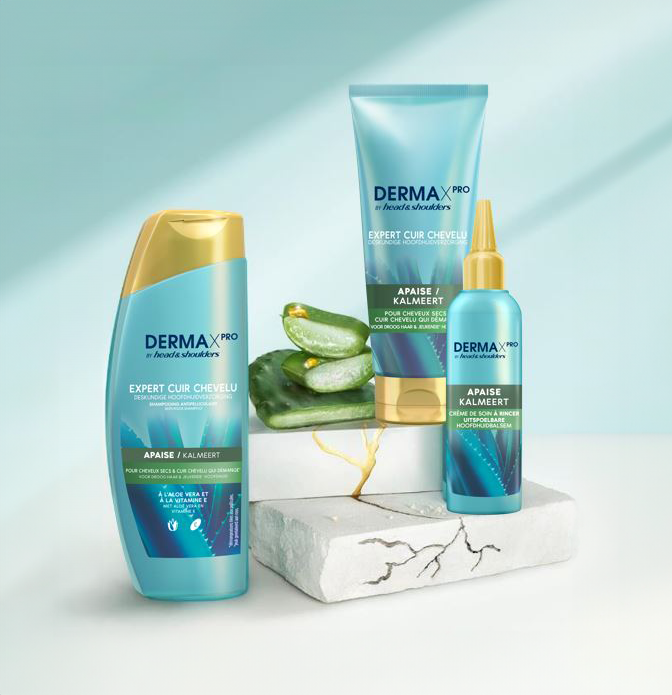 Derma X Pro Soothing comfort Bouteilles de shampoing, revitalisant et baume pour le cuir chevelu Head & Shoulders, à côté de morceaux d'aloès et de cactus