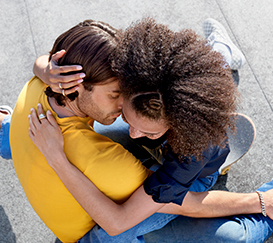 homme avec t shirt jaune et femme aux cheveux bouclés