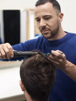 coiffeur qui coupe les cheveux d'un homme