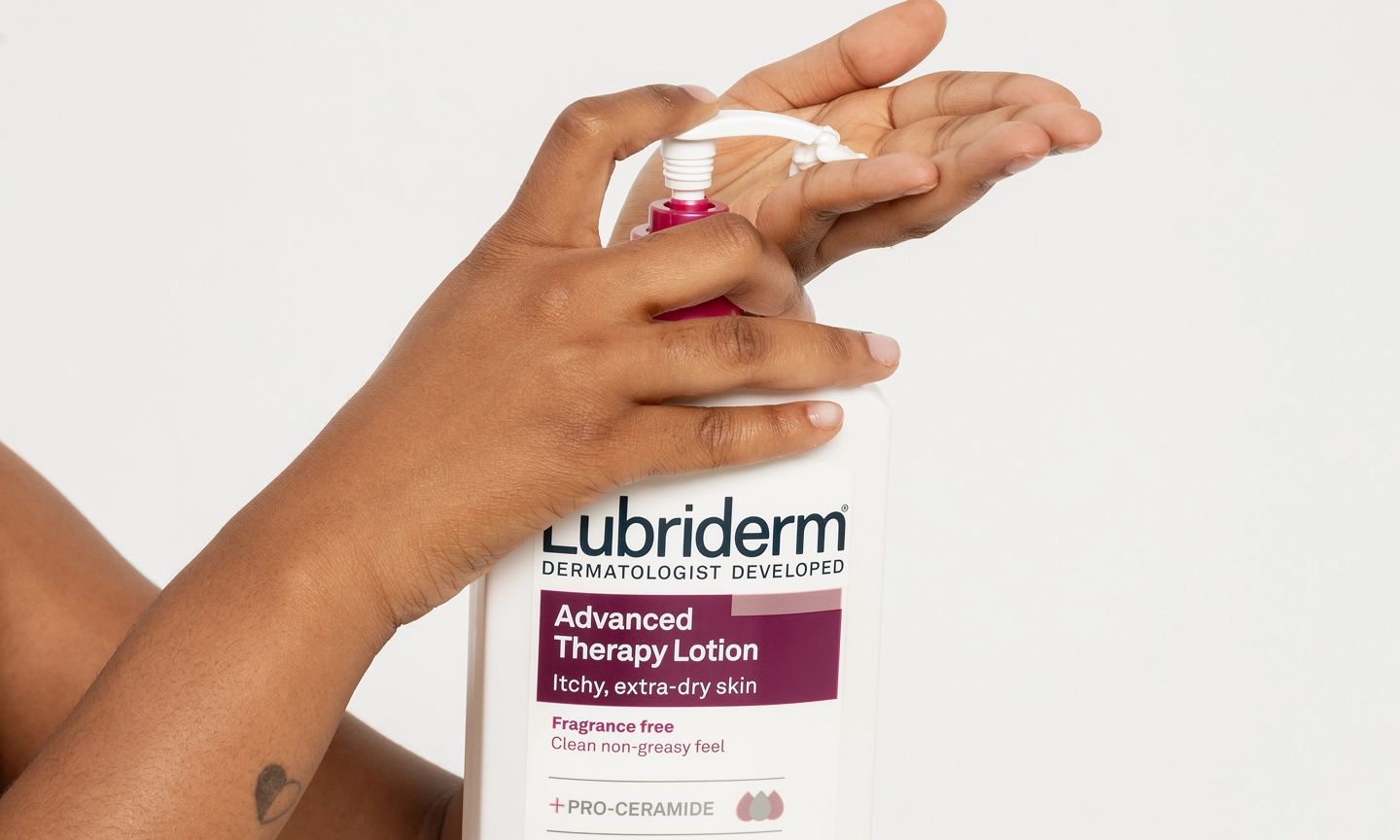 Person gently applying lotion on hands, featuring Lubriderm® advanced therapy lotion