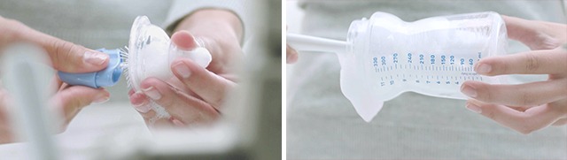 Hand using soapy bottle brush and nipple brush to wash bottle and plastic nipples