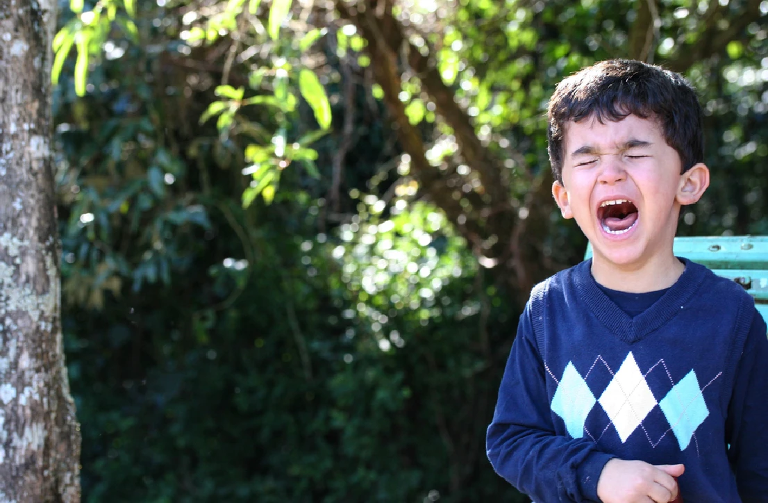 Crying child holding stomach area