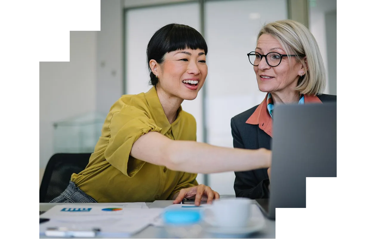 Two business colleagues discussing documents at a table in the office