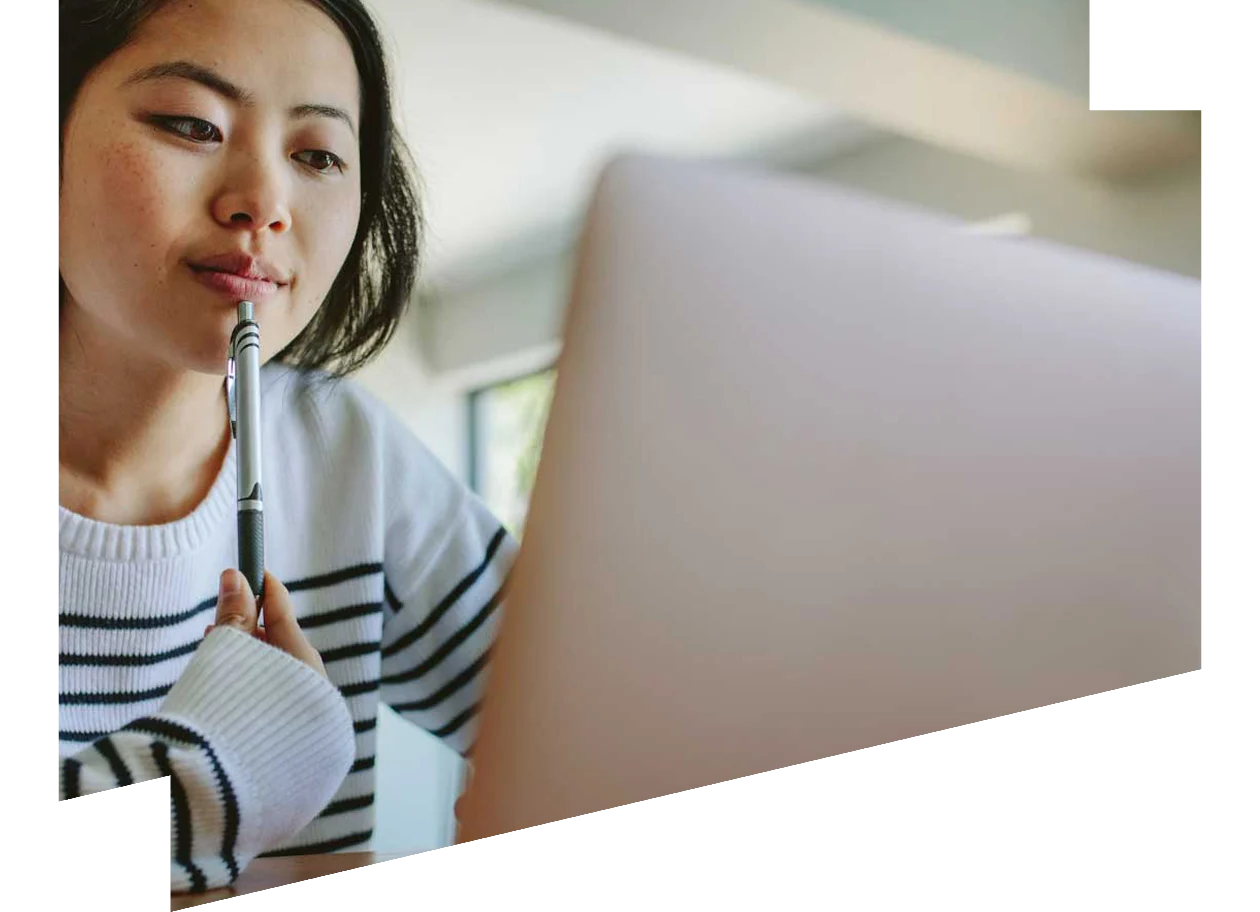 Thoughtful looking young female studying on a laptop